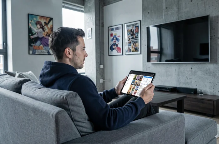 Homme consultant un sitemap structuré de séries et animes sur une tablette dans un salon moderne